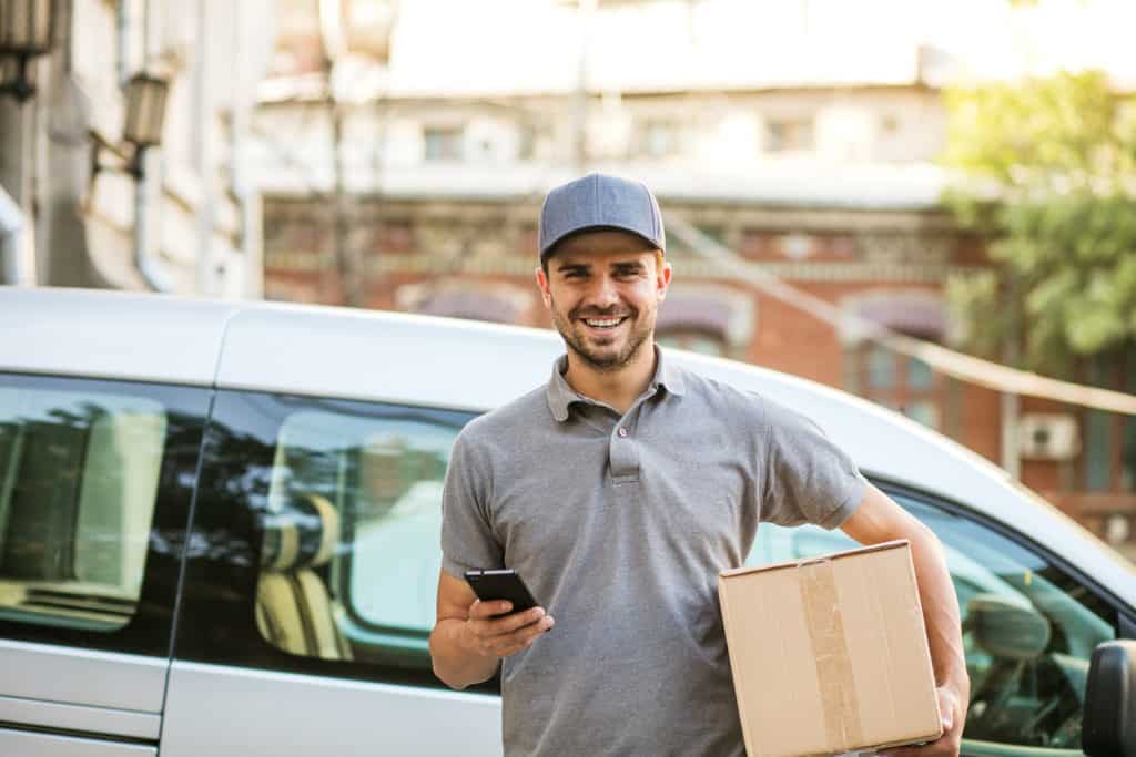a happy last mile delivery driver confirms delivery in his Wise Systems mobile driver app