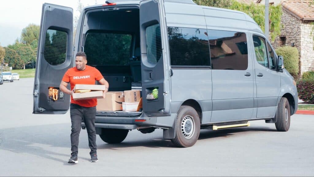 Driver stepping outside of van with package