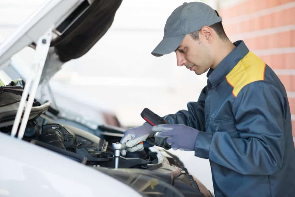 A mechanic performing routine maintenance on a van 