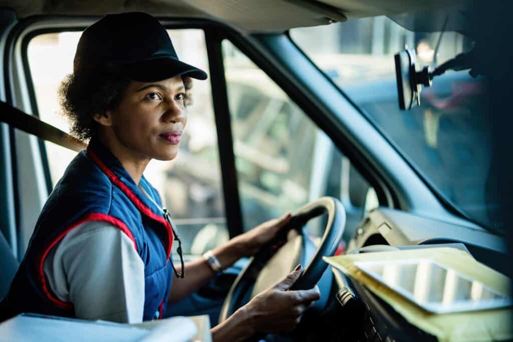 Woman delivery driver in the cab of her van