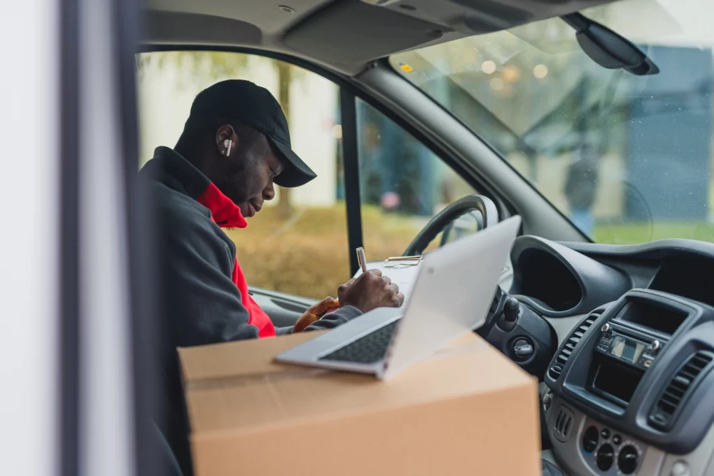 Delivery driver with a laptop open to view a territory plan 