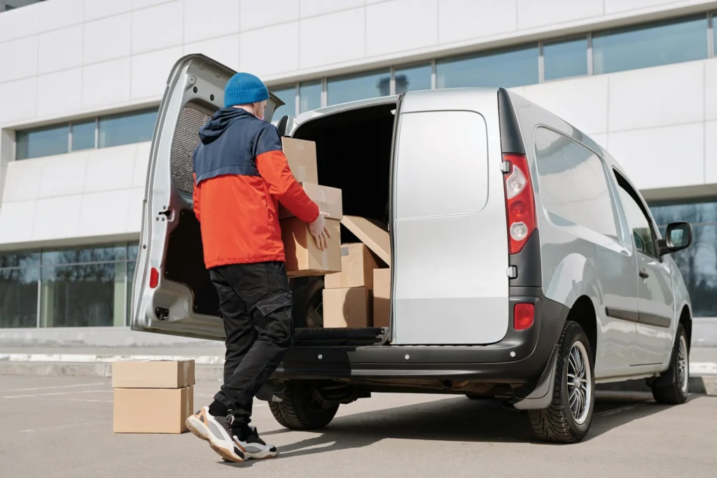 Delivery driver loading packages into a delivery van