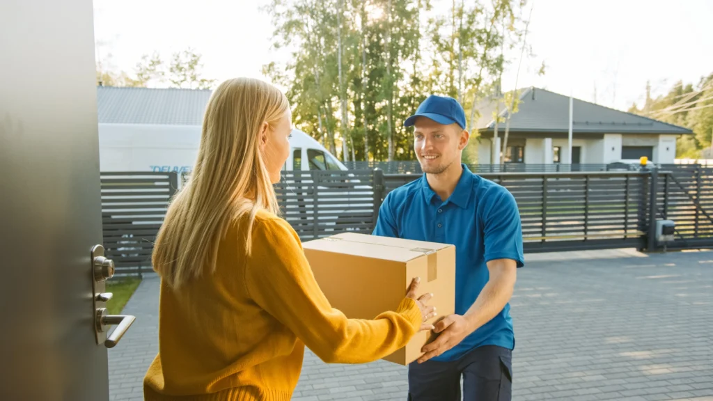 Delivery driver handing a package to a customer in a neighborhood