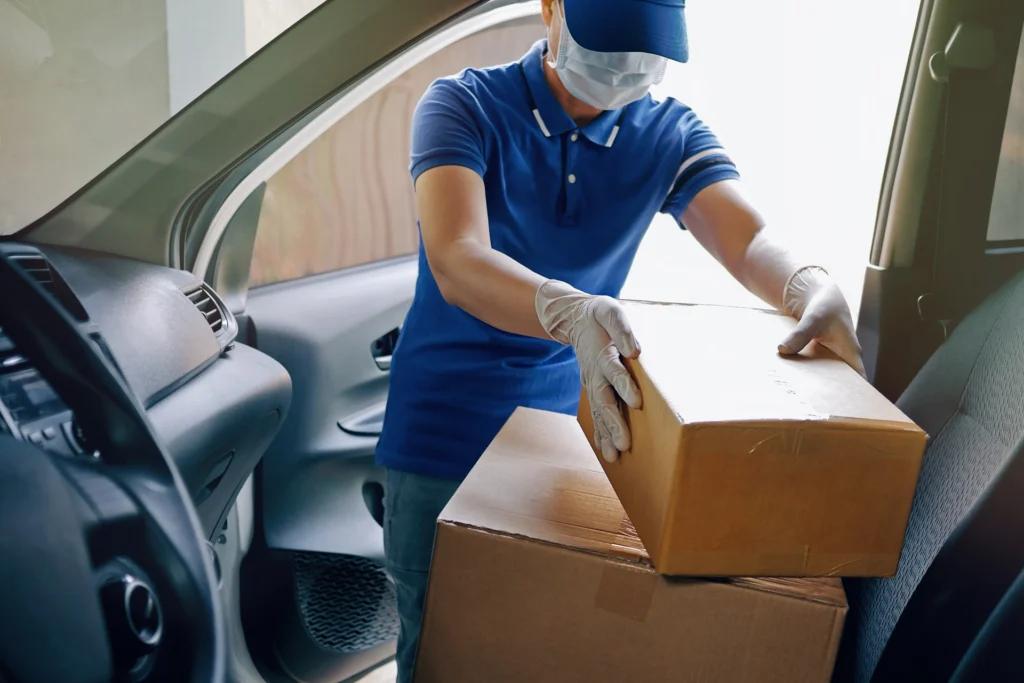 eCommerce delivery during COVID, delivery professional wearing a mask and gloves to deliver a package